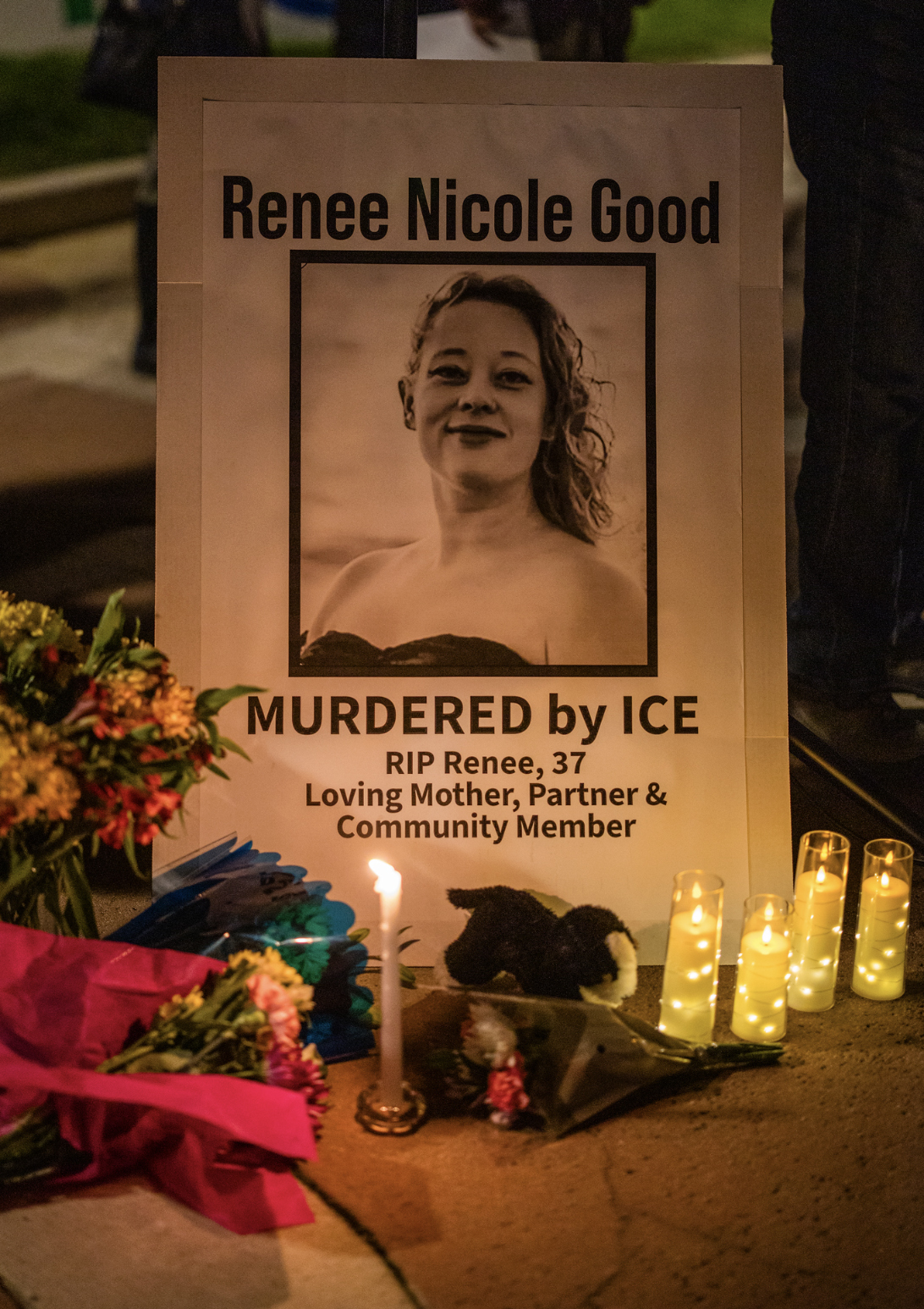 Candles, flowers, and signs form a memorial space at the center of King Plaza.